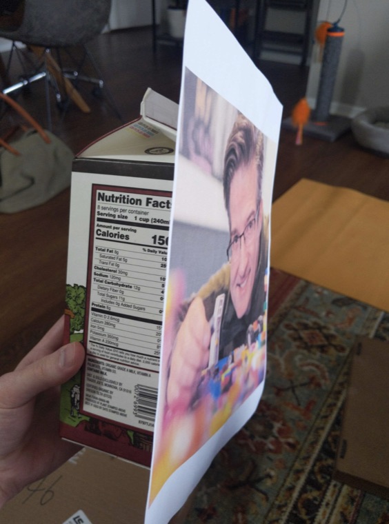 A hand holding a paper prototype card up to the camera.